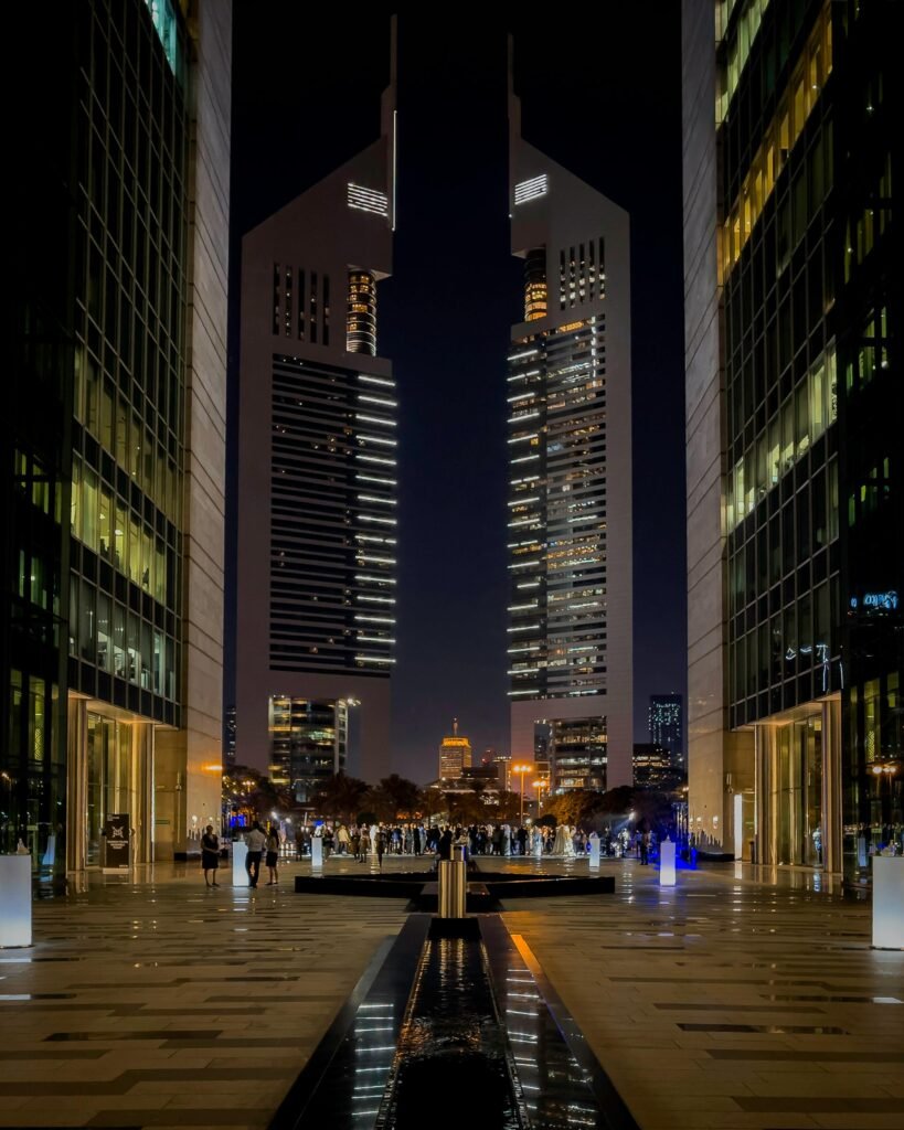 A stunning night view of Dubai's iconic twin towers, reflecting modern architecture and urban life.